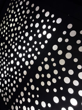 Abstract Pattern of Illuminated Circles on Dark Perforated Surface
