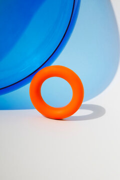 Orange torus with blue curved geometry on white background