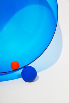 Minimal blue glass geometry with red and blue sphere