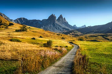 Winding gravel path through alpine valley with Aiguilles d Arves mountain peaks in French Alps during autumn © Mumemories