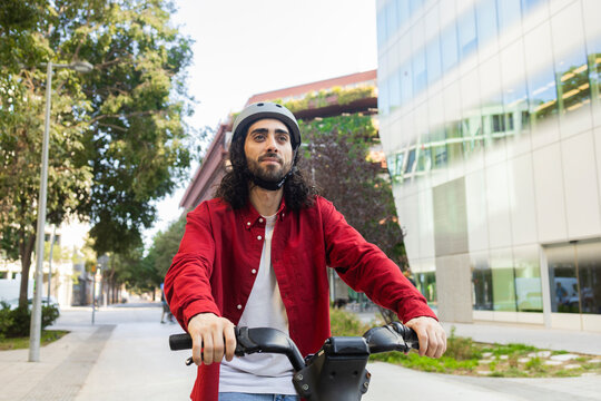 Man riding electric bike through modern city street