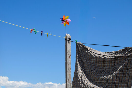 Colorful pinwheel on clothesline against clear blue sky