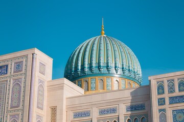 Close view of the turquoise dome and intricate Islamic tilework of Minor Mosque in Tashkent, Uzbekistan, showcasing elegant architecture against a clear blue sky. © Kolchanov