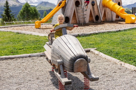 Child playing on wooden ride at Piz la Ila playground