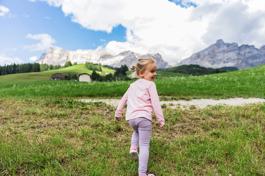 Child walking through alpine meadow in the Dolomites