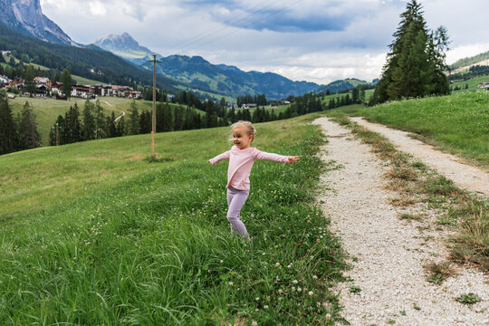 Child explore alpine meadow near La Villa in the Dolomites