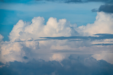Fototapeta premium Dramatic white cumulus clouds and layered formations floating across a bright blue sky, captured from Mount Shijiutou in New Taipei City, Taiwan.