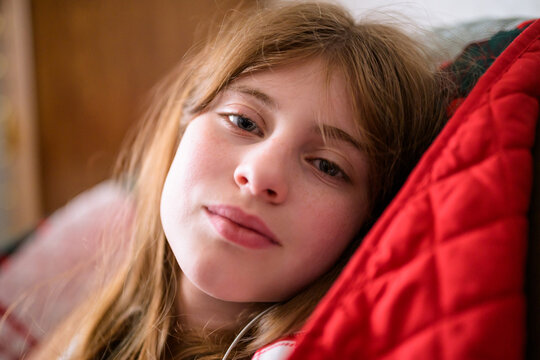 Serene adolescent relaxing on couch in natural indoor light