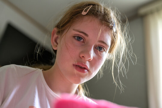 Thoughtful preteen girl with hair clips at home indoors