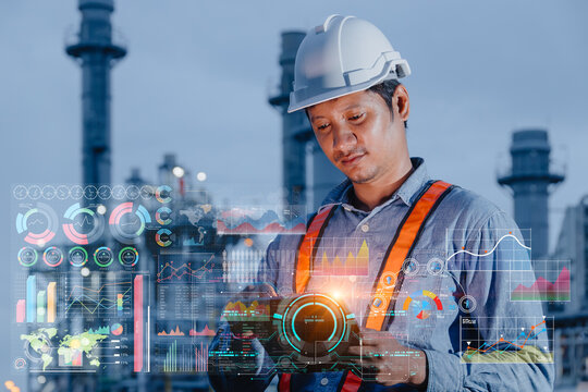 Refinery engineer worker using tablet device monitor display digital analytics dashboard Industrial information data at oil and gas plant nightshift work in power plant