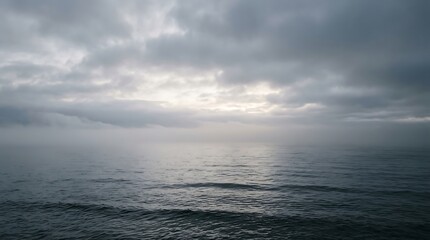 Fototapeta premium A serene view of the calm ocean under a dramatic cloudy sky during a peaceful sunset