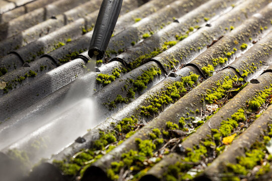 washing corrugated roof from dirt and moss with high pressure washer