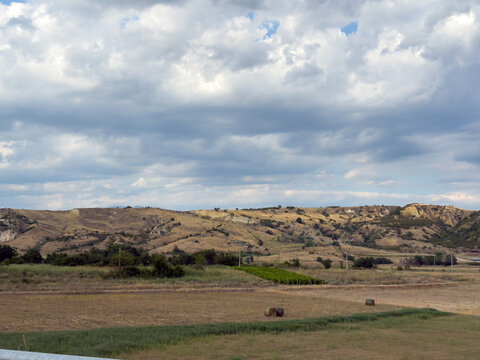 Agricultural fields beneath dramatic cloudy countryside sky