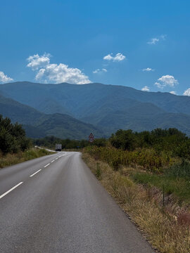Mountain road leading toward scenic green summer ridges