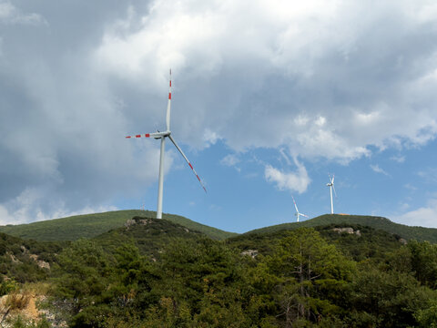 Wind Turbines Across Green Mountain Ridge Under Clouds