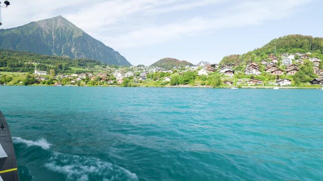 Point of view shot from a boat navigating the turquoise waters of lake thun in switzerland. Switzerland
