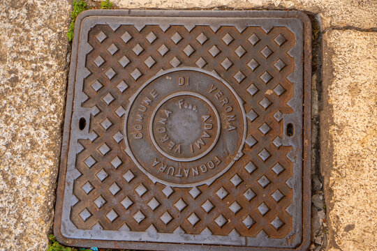 Square Cast Iron Manhole Cover with Inscription Commune di Verona on Pavement Street in Italy. Verona, Italy - June 25, 2026