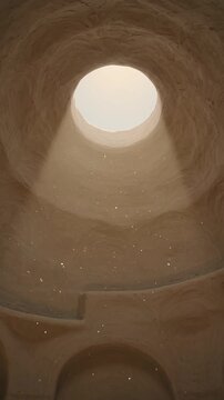 Light pours down a curved, stone dome