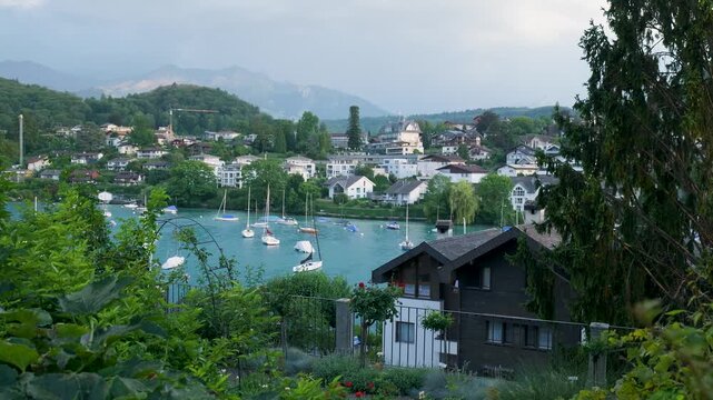 Picturesque town on the shores of lake thun in switzerland, with sailboats moored in the blue water. Switzerland