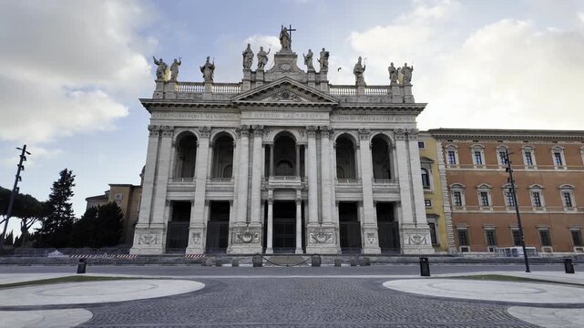 Exterior view of the monumental main facade and statues of the Archbasilica of Saint John Lateran, the cathedral of the Bishop of Rome and oldest papal basilica in Rome, Italy.