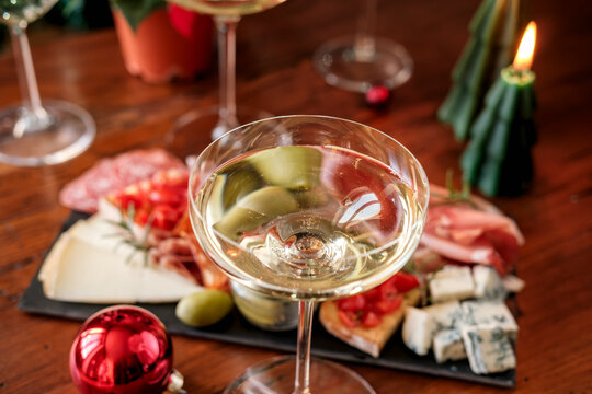 Christmas Holiday Celebration With Champagne Glasses And Charcuterie Board By A Decorated Tree