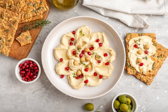 Creamy Hummus Bowl With Pomegranate Seeds, Chickpeas, Olive Oil and Rustic Bread