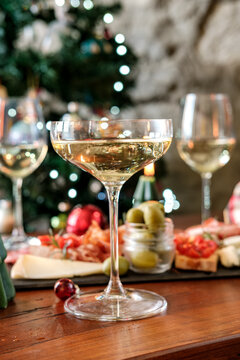 Christmas Holiday Celebration With Champagne Glasses And Charcuterie Board By A Decorated Tree