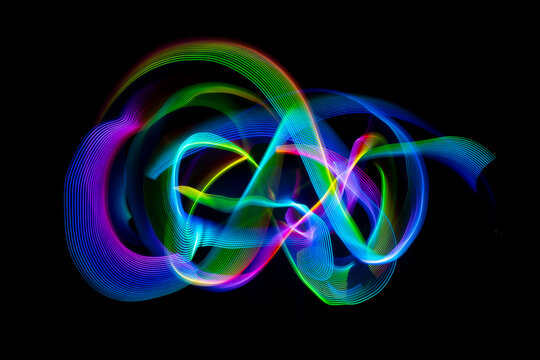 Colorful light painting creating swirling trails on dark background