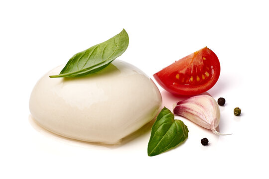 Fresh mozzarella ball with basil leaves, tomato wedge, garlic clove, peppercorns, and clean styling on white background for culinary presentation and menu use, with mozzarella, cheese, basil, tomato
