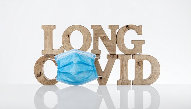 Minimalist white background with wooden letters spelling LONG COVID placed before blue disposable face mask, symbolizing lingering pandemic health concerns.