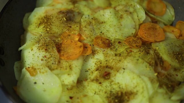 Cooking layered potatoes and carrots in a pan