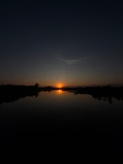 Obraz premium Golden Sunset Reflected in a Calm Lake