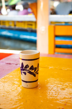 Traditional Mexican tequila shot glass on wooden table aboard a trajinera