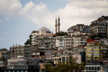 Fototapeta premium Residential buildings and mosque minarets located on a steep city hill in Istanbul. Traditional Turkish urban landscape and historic architecture concept.