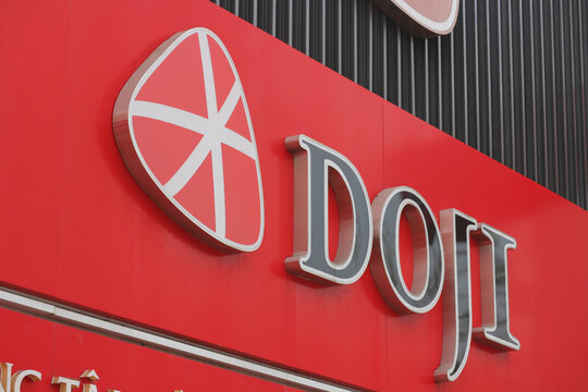 VUNG TAU, VIETNAM - FEBRUARY 5, 2026: The corporate exterior signboard and red facade of a DOJI Gold and Gems Group jewelry store branch.