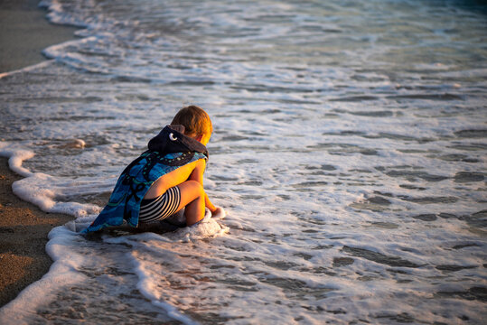 Child enjoying in gentle waves during summer vacation on exotic tropical beach.