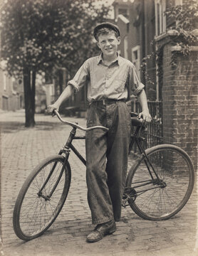 Proud 1940s boy standing beside his bicycle