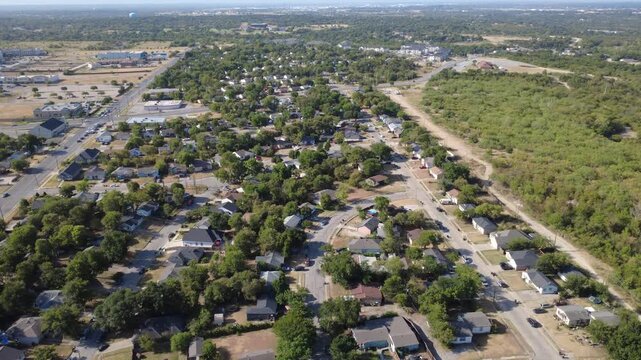Paved neighborhood streets cross quiet residential subdivisions across DFW suburbs. Clustered single-story properties border vast natural greenway forest preserves, Fort Worth, Texas