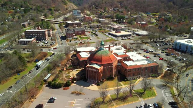 Aerial 180-degree orbit around First Baptist Church of Asheville with copper dome