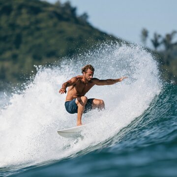 Surfer carving a powerful ocean wave with dramatic spray for action sports banner and summer water background