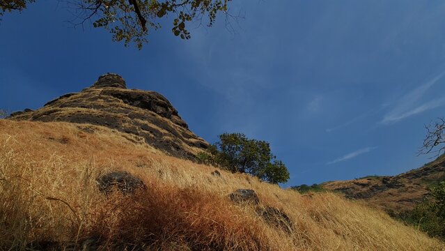 Rugged Rocky Mountain Peak and Dry Grassland Landscape in the Sahyadri Mountains, Maharashtra