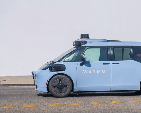 Los Angeles, CA, USA: August 22, 2026: A Waymo autonomous taxi drives down La Brea Avenue in Los Angeles, CA. The blue custom-built electronic robotaxi is named the Ojai.