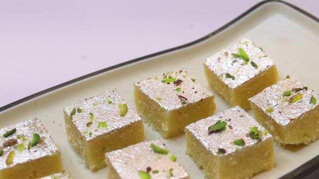 Milk barfi decorated with silver and dry fruits plated on white plate