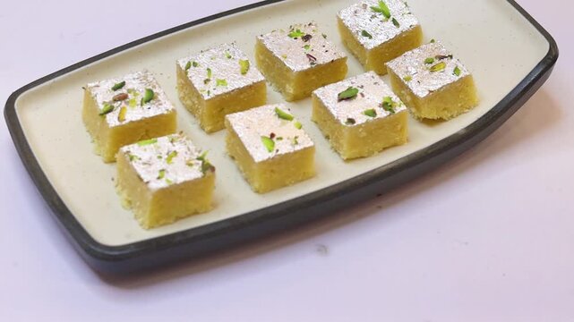 Milk barfi decorated with silver and dry fruits plated on white plate