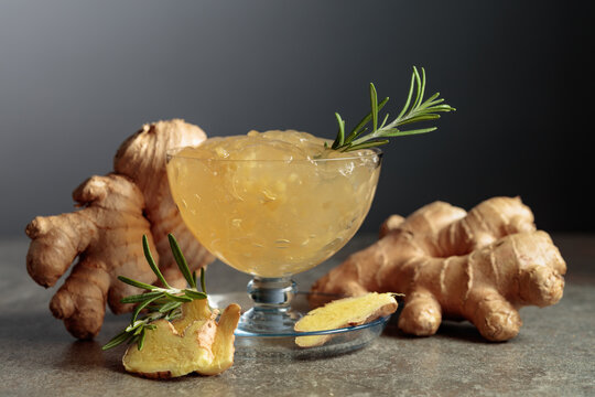Ginger jam in glass dish garnished with rosemary branches.