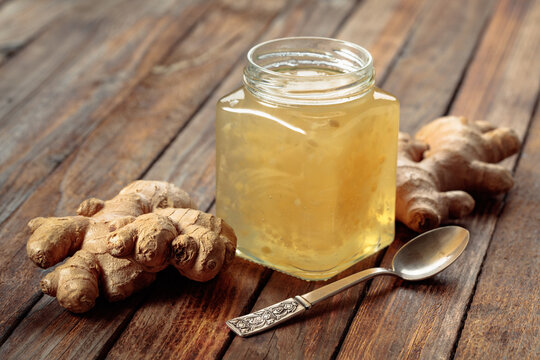 Ginger jam in jar and fresh ginger roots.