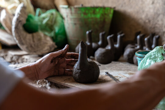 Artisan hands sculpting clay pottery in workshop