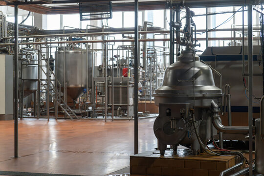 Industrial dairy plant interior with stainless steel separator machine