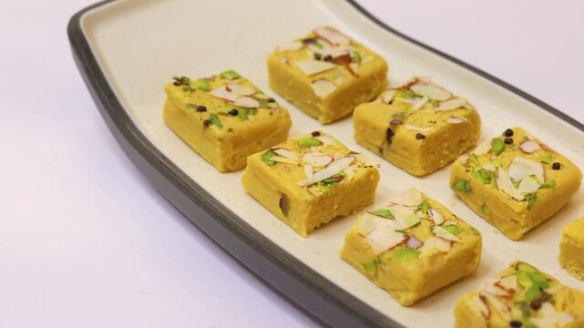 Soan papdi garnished with dry fruits plated on white plate