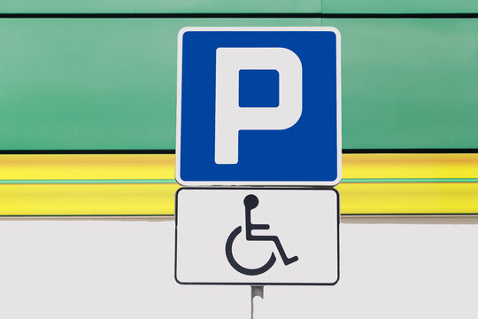 Parking sign marks reserved space. Wheelchair symbol marks disabled parking. Blue sign indicates accessible mobility. Public parking supports equal access. City parking forms practical background.